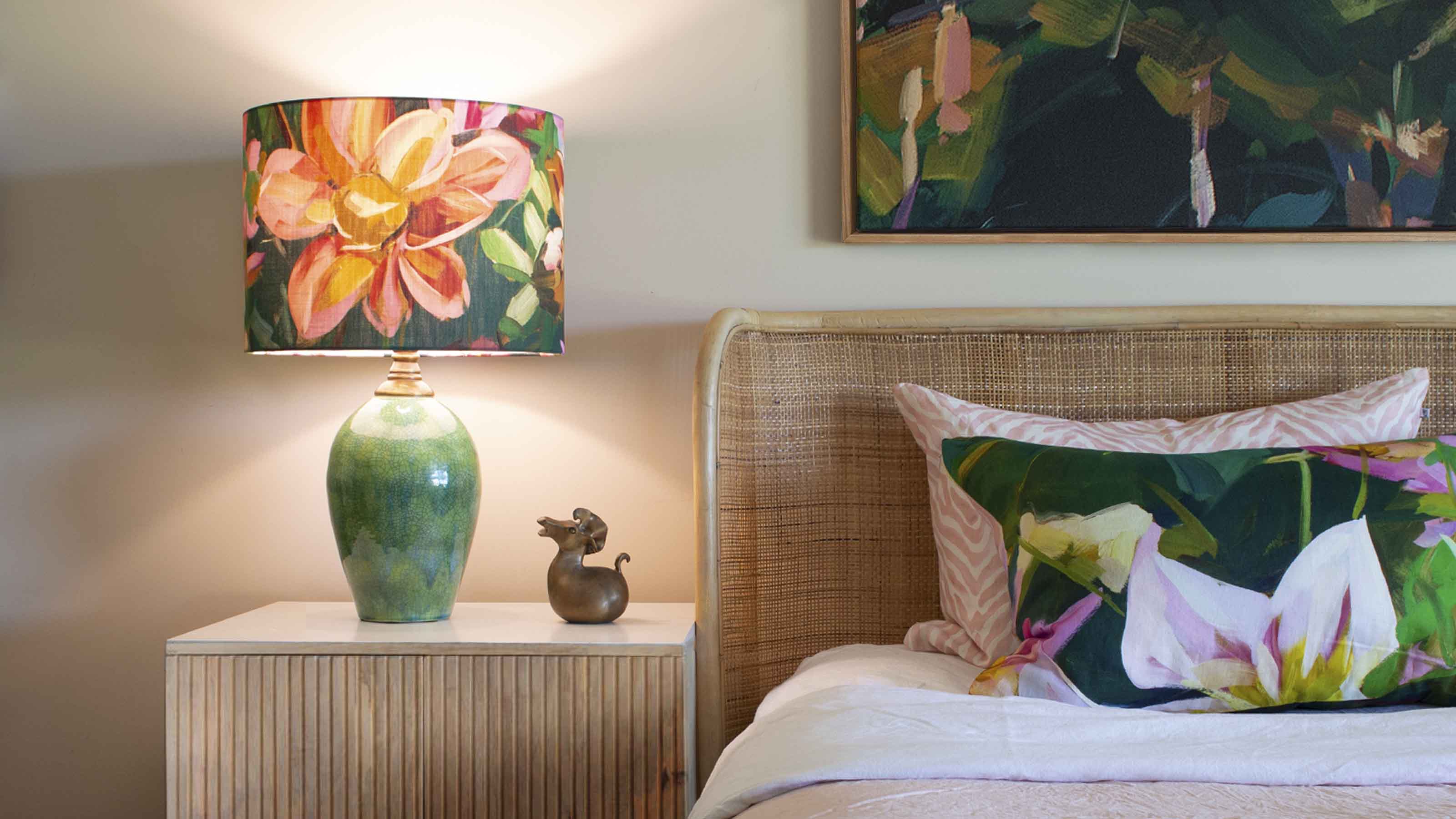 Bedroom styled for an interior design consultation checklist, featuring botanical lampshade, green ceramic lamp base and layered art cushions.