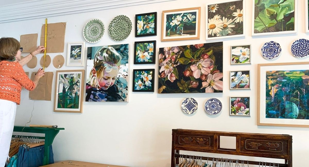 Interior designer arranging artwork on a gallery wall, showing the process of hiring an interior designer with confidence and clarity.