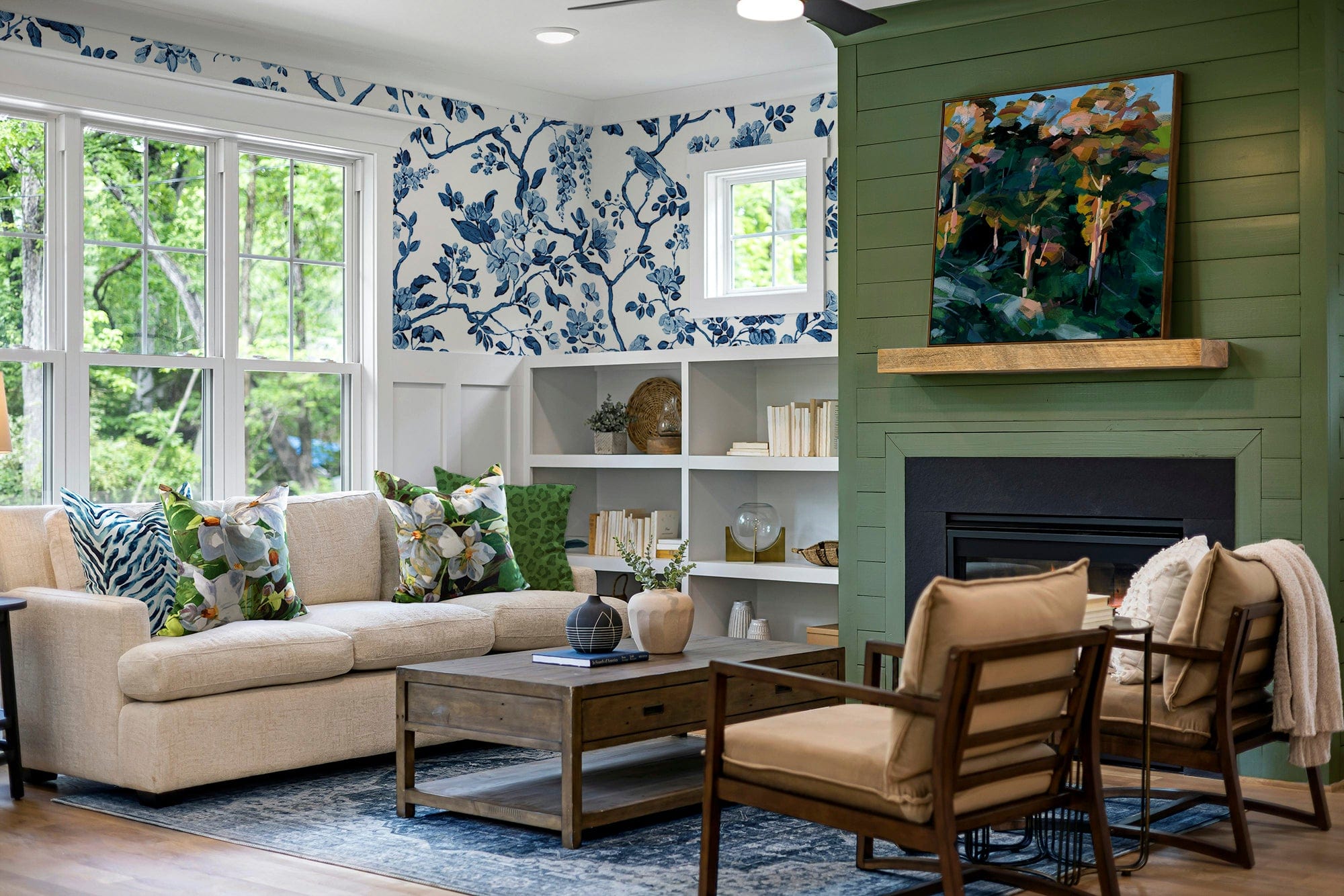 Living room styled with botanical wallpaper, layered fabrics and artwork, creating a warm, art-filled interior.